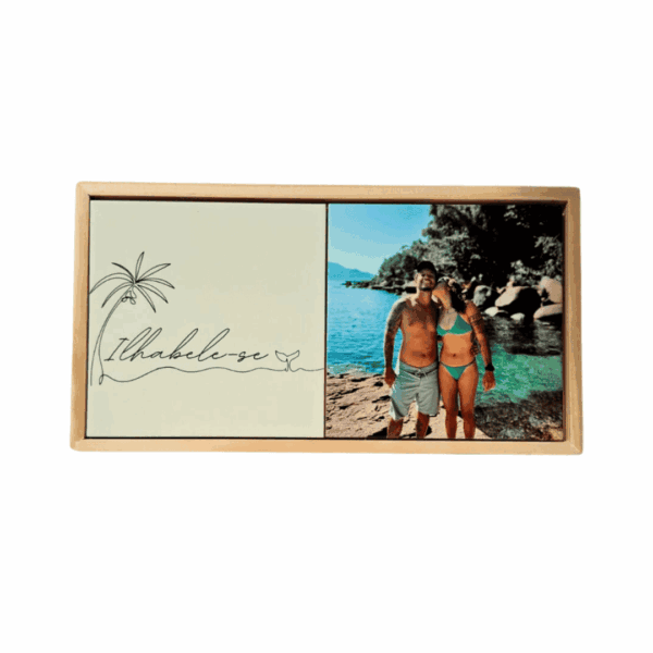 Moldura de madeira com dois azulejos lado a lado: arte Ilhabela e foto de casal na praia