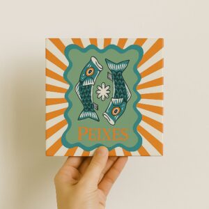 Mão segurando o azulejo decorativo Signo de Peixes