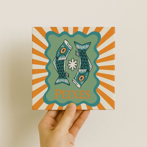 Mão segurando o azulejo decorativo Signo de Peixes