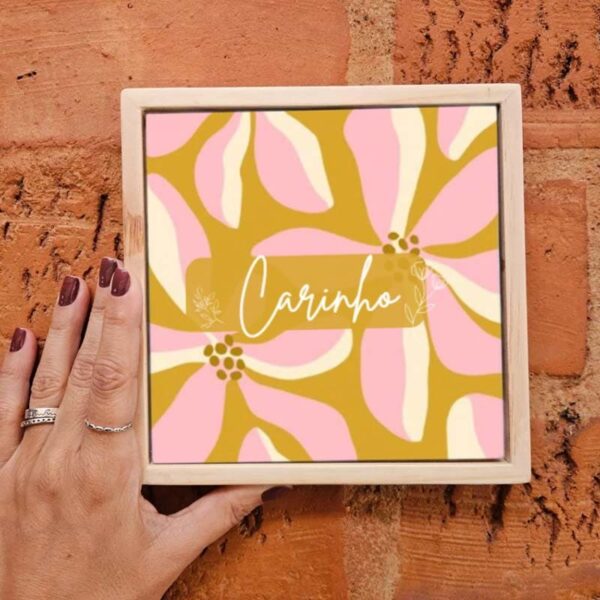 Mão segurando o azulejo decorativo Carinho
