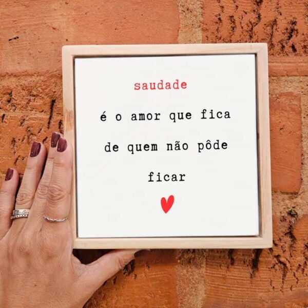 Mão segurando o azulejo decorativo Saudade é o Amor de Quem Não Pôde Ficar