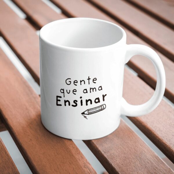 Caneca Gente que Ama Ensinar sobre a mesa de madeira