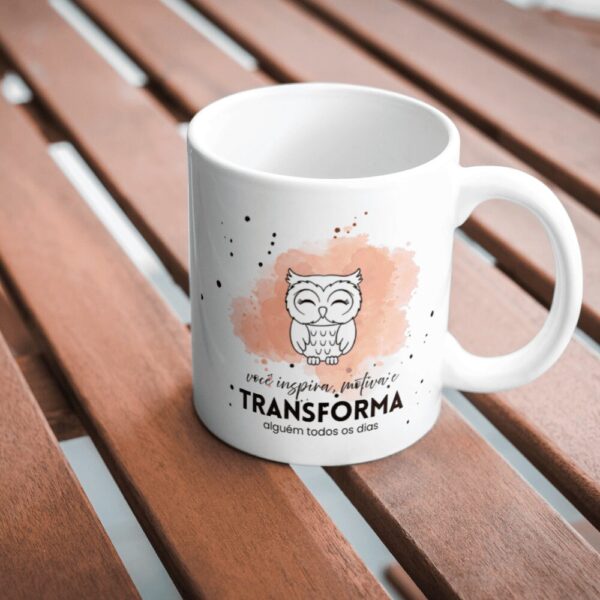 Caneca Você Inspira, Motiva e Transforma com corujinha, sobre mesa de madeira