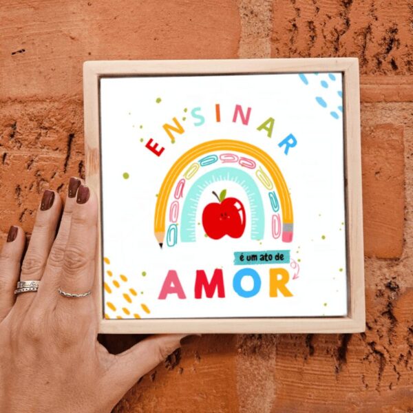 Mão segurando o azulejo Ensinar é um Ato de Amor com moldura de madeira, presente para professora
