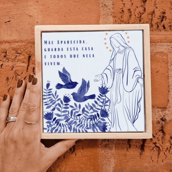 Mão segurando o azulejo decorativo Mãe Aparecida, Guarda Esta Casa e Todos que Nela Vivem