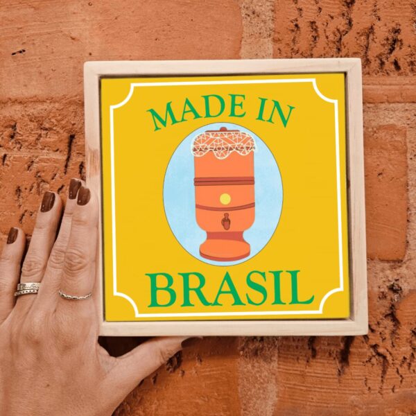 Mão segurando o azulejo decorativo Filtro de Barro Made in Brasil