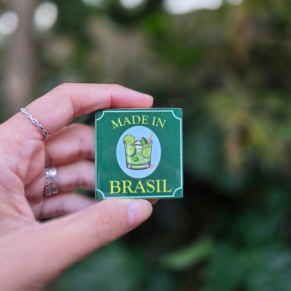 Mão segurando o mini azulejo com ímã Made in Brasil