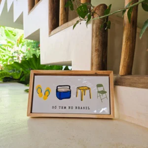 Azulejo decorativo 10x20 cm "Só Tem no Brasil" com ilustrações de havaianas, isopor azul, mesa plástica amarela e cadeira dobrável verde, com moldura de madeira