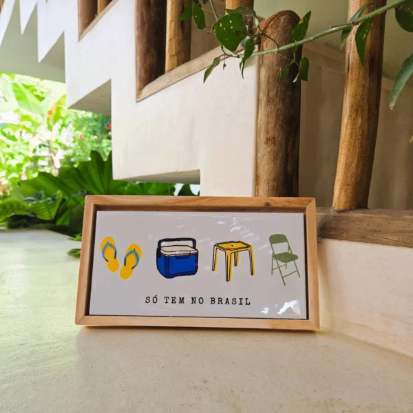 Azulejo decorativo 10x20 cm "Só Tem no Brasil" com ilustrações de havaianas, isopor azul, mesa plástica amarela e cadeira dobrável verde, com moldura de madeira