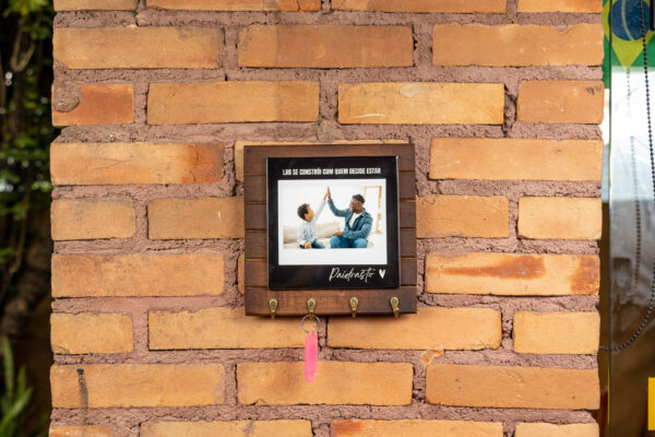 Porta-chaves personalizado com azulejo e foto de pai e filho, na parede de tijolos